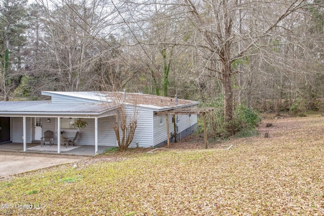 view of side of home with a carport and a yard