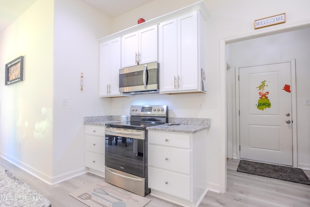 75 Dry Field Cv, Byhalia, MS 38611 - kitchen with stainless steel appliances, light wood-style flooring, white cabinetry, and light stone countertops
