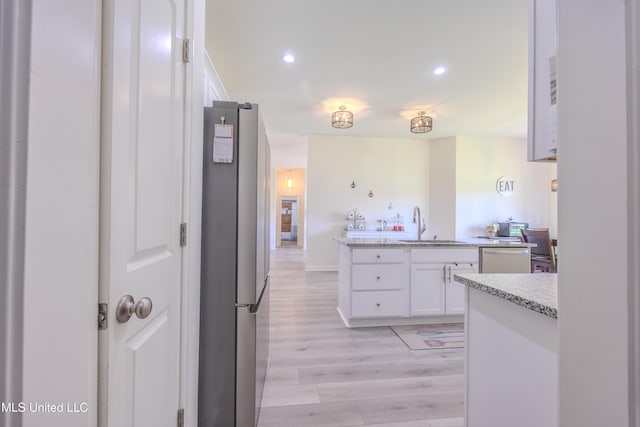 75 Dry Field Cv, Byhalia, MS 38611 - kitchen featuring appliances with stainless steel finishes, white cabinets, light wood finished floors, recessed lighting, and light stone counters