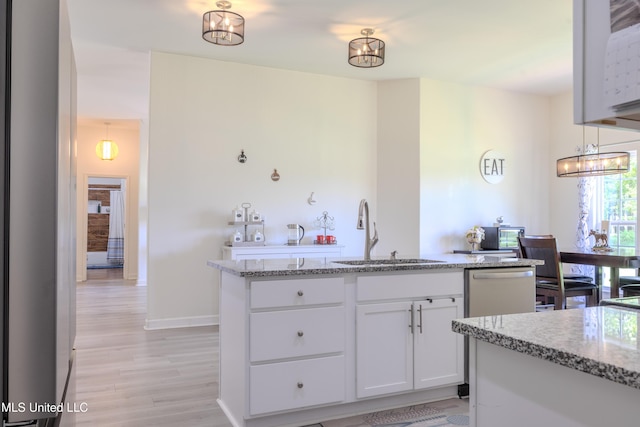 75 Dry Field Cv, Byhalia, MS 38611 - kitchen featuring light wood finished floors, light stone counters, white cabinets, and a center island with sink