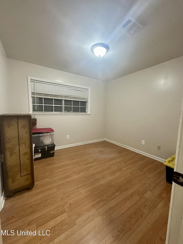 unfurnished room with visible vents, baseboards, and wood finished floors