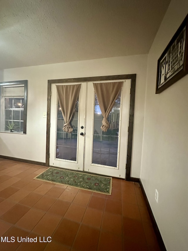 entryway with baseboards and french doors