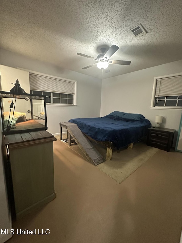 carpeted bedroom featuring visible vents, a textured ceiling, and ceiling fan