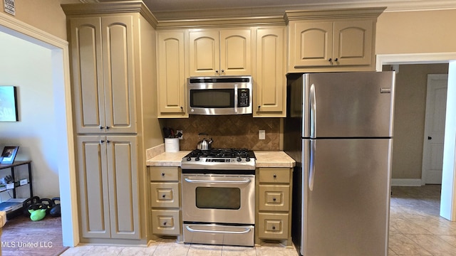 kitchen featuring appliances with stainless steel finishes, crown molding, tasteful backsplash, and light tile patterned floors