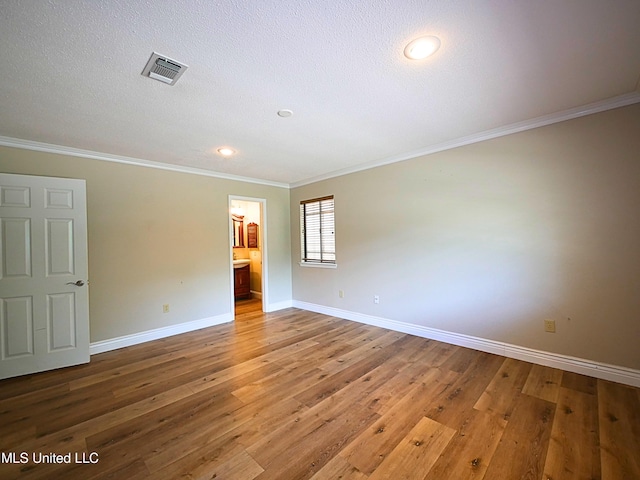 empty room with baseboards, ornamental molding, light wood-style flooring, recessed lighting, and a textured ceiling