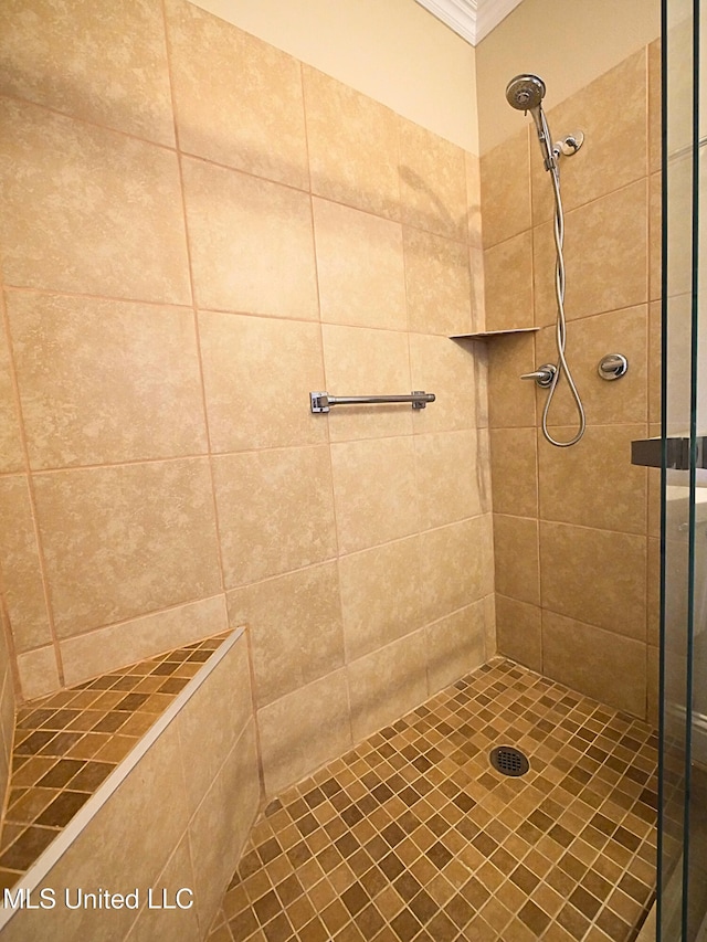 bathroom featuring tiled shower and crown molding