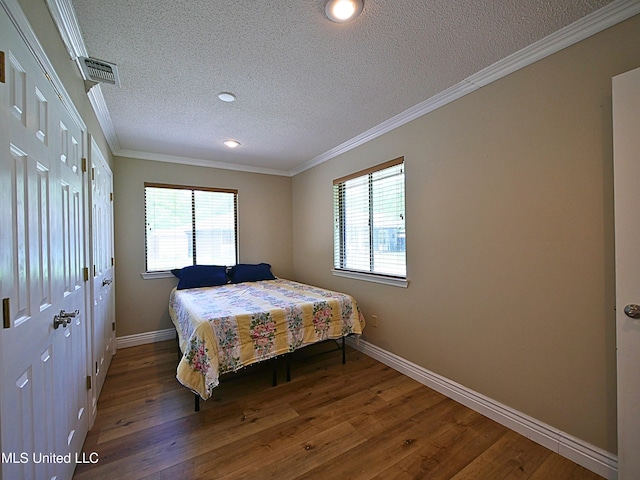 bedroom featuring a textured ceiling, baseboards, wood finished floors, crown molding, and recessed lighting