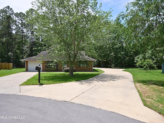 view of front of property featuring concrete driveway, a front yard, and an attached garage