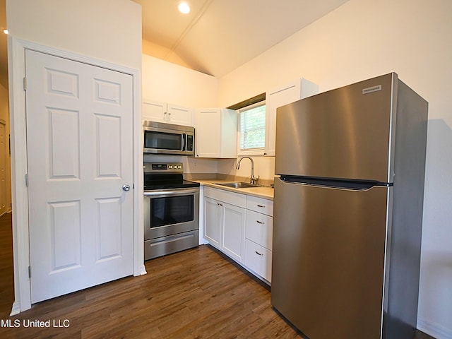 kitchen featuring stainless steel appliances, a sink, lofted ceiling, white cabinets, and dark wood-style floors