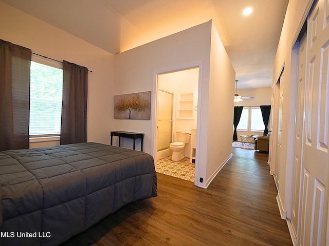 bedroom with dark wood-style flooring, baseboards, and connected bathroom