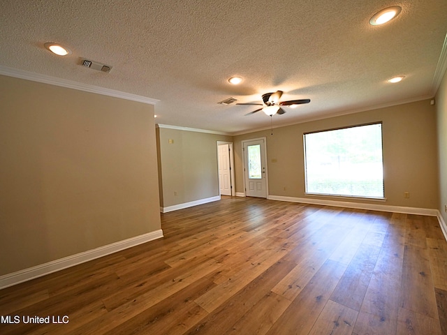 spare room featuring dark wood-style floors, ceiling fan, baseboards, crown molding, and a textured ceiling