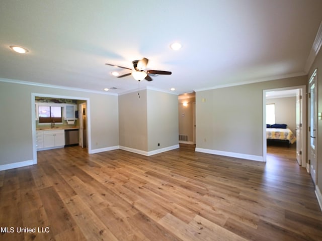 unfurnished living room with ornamental molding, a ceiling fan, wood finished floors, recessed lighting, and baseboards