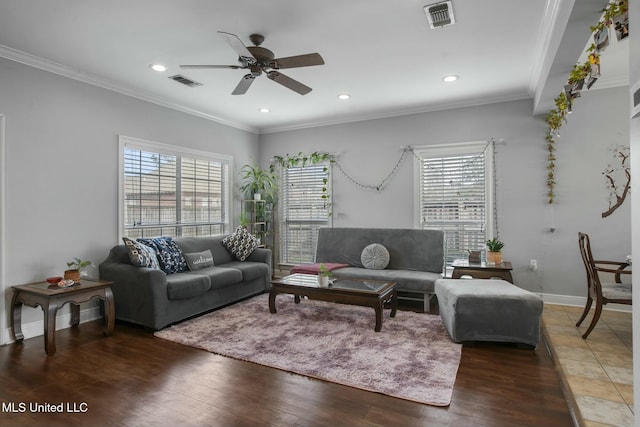 living area featuring crown molding, plenty of natural light, wood finished floors, and visible vents