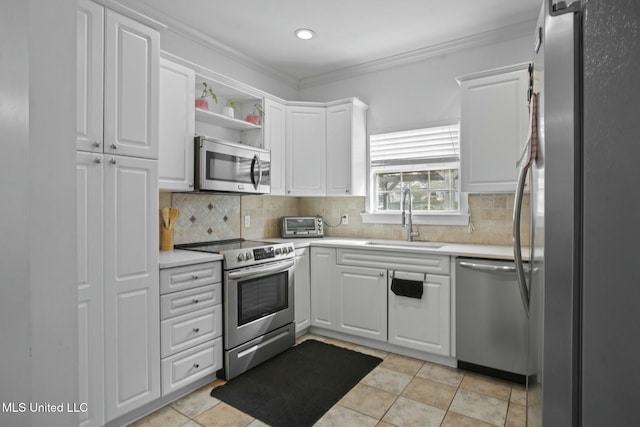 kitchen featuring backsplash, light countertops, stainless steel appliances, white cabinetry, and a sink