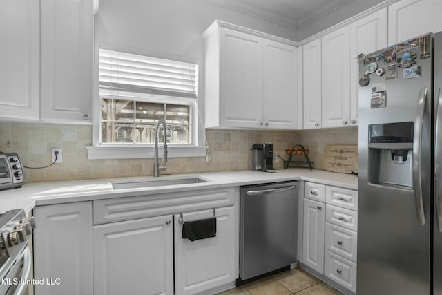 kitchen featuring backsplash, white cabinets, stainless steel appliances, and a sink