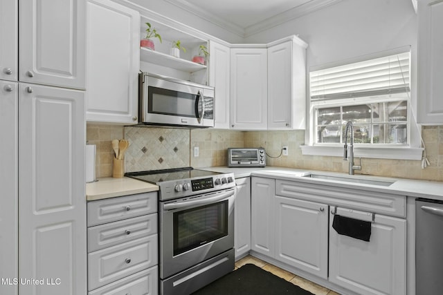 kitchen featuring a sink, white cabinets, tasteful backsplash, and stainless steel appliances