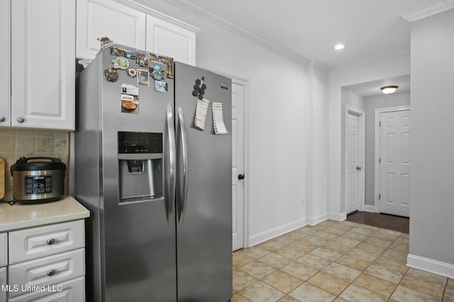 kitchen featuring crown molding, white cabinets, stainless steel fridge with ice dispenser, and backsplash