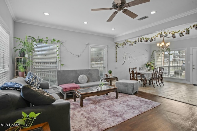 living room with visible vents, ornamental molding, recessed lighting, ceiling fan with notable chandelier, and wood finished floors