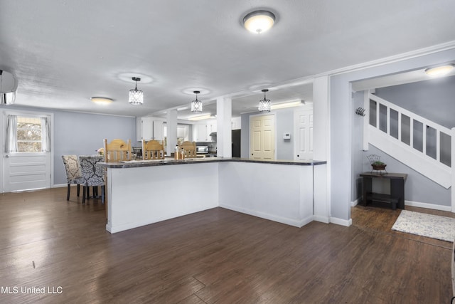 kitchen with white cabinetry, decorative light fixtures, dark wood-type flooring, and kitchen peninsula