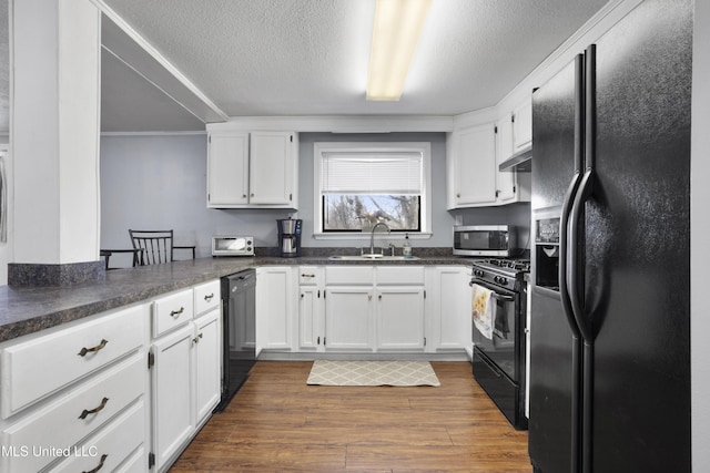 kitchen with white cabinetry, sink, dark hardwood / wood-style flooring, black appliances, and a textured ceiling