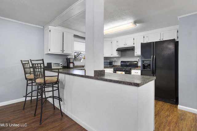 kitchen with white cabinetry, dark hardwood / wood-style floors, kitchen peninsula, and black appliances