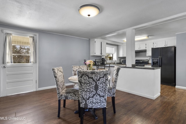 dining space with dark hardwood / wood-style flooring, sink, and a textured ceiling