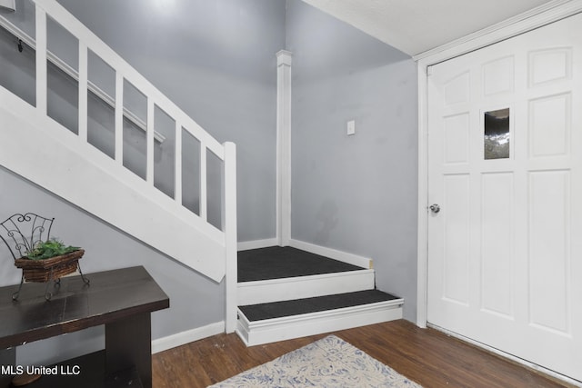 foyer entrance with dark hardwood / wood-style floors and ornate columns