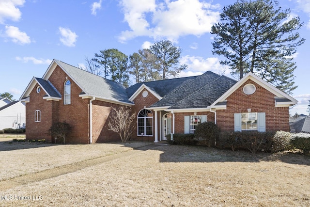 view of front of home with roof with shingles and brick siding