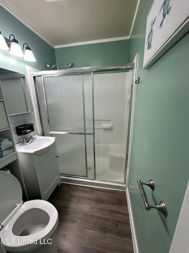 bathroom featuring wood-type flooring, crown molding, an enclosed shower, and vanity