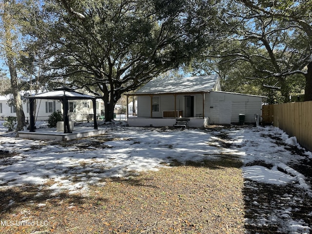 snow covered back of property featuring a gazebo