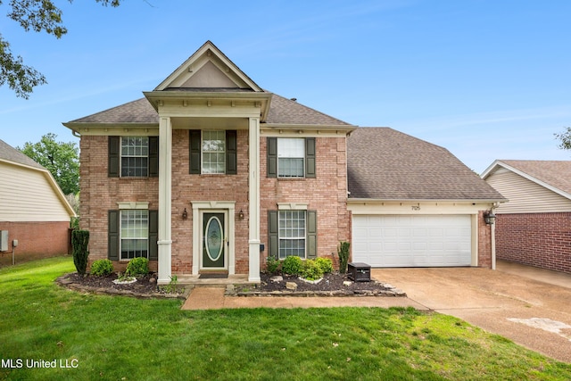 7125 Creekside Dr, Olive Branch, MS 38654 - greek revival inspired property featuring a garage, concrete driveway, a front yard, a shingled roof, and brick siding