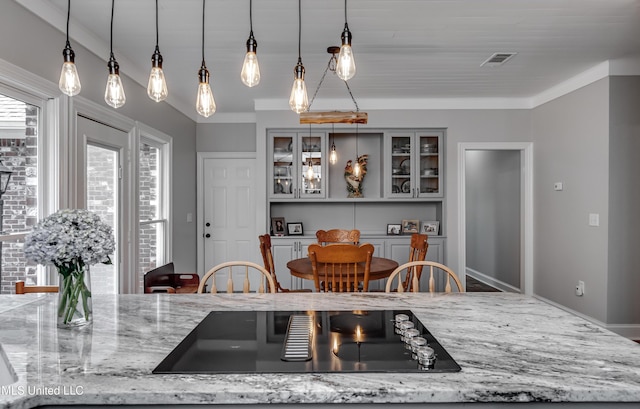 209 Lake Terrace Pl, Brandon, MS 39047 - kitchen featuring black electric stovetop, hanging light fixtures, light stone countertops, and glass insert cabinets