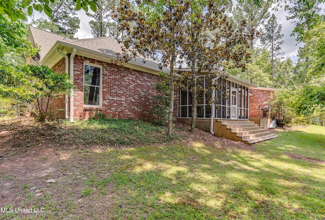 209 Lake Terrace Pl, Brandon, MS 39047 - rear view of house featuring a sunroom, brick siding, roof with shingles, and a lawn