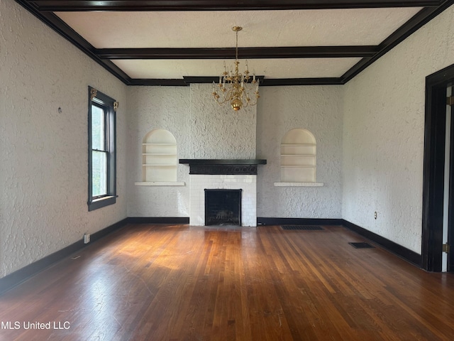 unfurnished living room with crown molding, a brick fireplace, a notable chandelier, beam ceiling, and dark hardwood / wood-style flooring