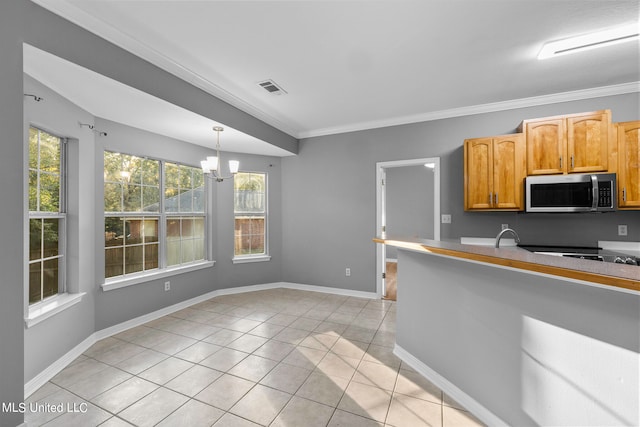 kitchen with light tile patterned floors, crown molding, an inviting chandelier, and pendant lighting