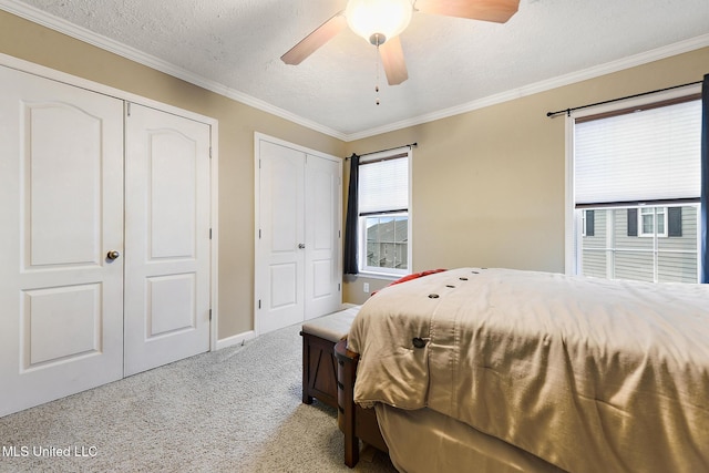 208 E Orchard Loop Unit 208, Diberville, MS 39540 - bedroom with light carpet, multiple closets, ornamental molding, a textured ceiling, and ceiling fan