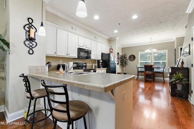 208 E Orchard Loop Unit 208, Diberville, MS 39540 - kitchen featuring black appliances, a kitchen breakfast bar, a peninsula, recessed lighting, and white cabinetry