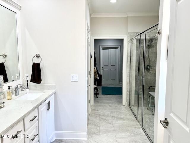 bathroom with vanity, ornamental molding, and a shower with door