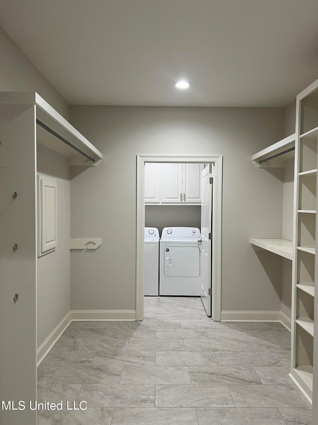 laundry room with washer and dryer and cabinets