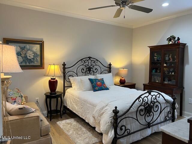 bedroom with ornamental molding, hardwood / wood-style floors, and ceiling fan