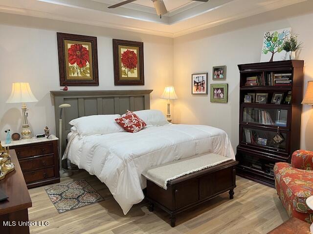 bedroom featuring ornamental molding, light hardwood / wood-style flooring, and ceiling fan