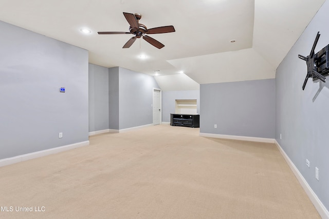 unfurnished living room featuring ceiling fan, light colored carpet, and vaulted ceiling