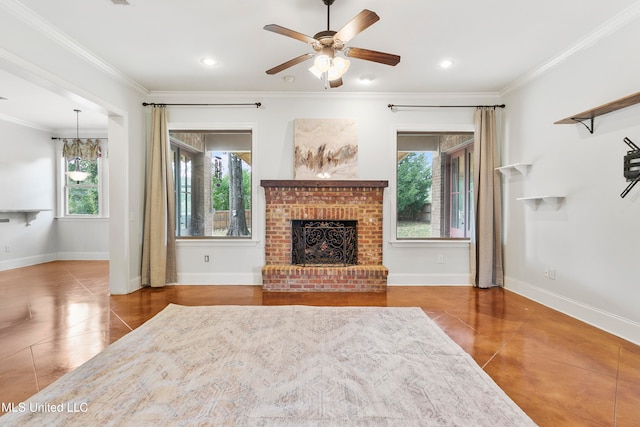 unfurnished living room featuring crown molding, ceiling fan, a healthy amount of sunlight, and a brick fireplace