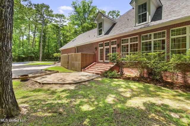 169 Pine Hill Dr, Brandon, MS 39047 - rear view of house with brick siding, a yard, and roof with shingles