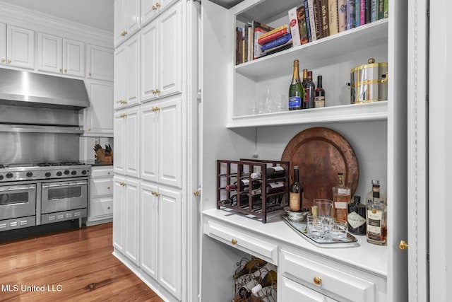 169 Pine Hill Dr, Brandon, MS 39047 - kitchen featuring under cabinet range hood, double oven range, white cabinetry, wood finished floors, and light countertops
