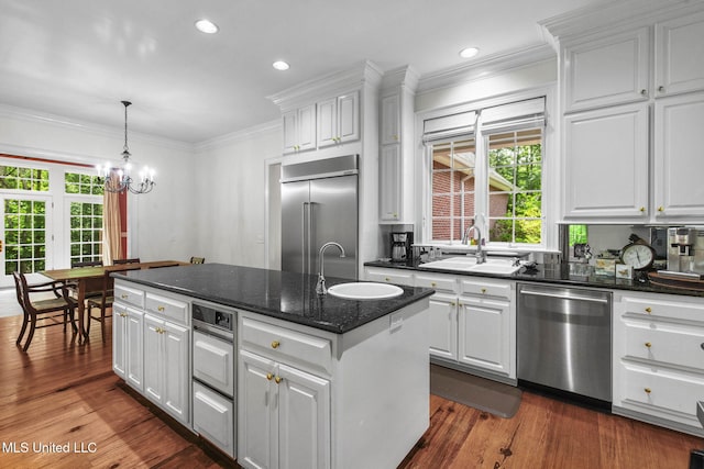 169 Pine Hill Dr, Brandon, MS 39047 - kitchen with stainless steel appliances, a kitchen island with sink, white cabinets, ornamental molding, and recessed lighting
