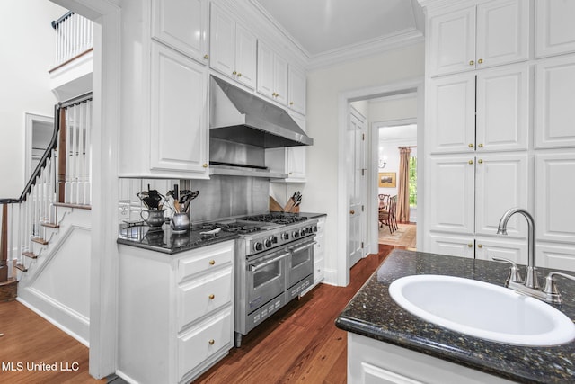 169 Pine Hill Dr, Brandon, MS 39047 - kitchen featuring range with two ovens, under cabinet range hood, white cabinetry, dark wood-style floors, and ornamental molding