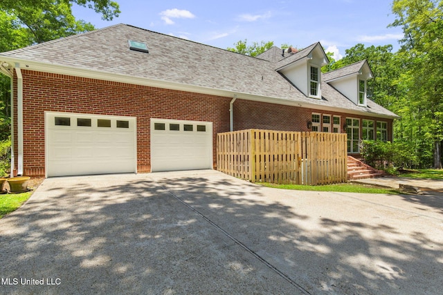 169 Pine Hill Dr, Brandon, MS 39047 - cape cod house with concrete driveway, a garage, brick siding, and a shingled roof