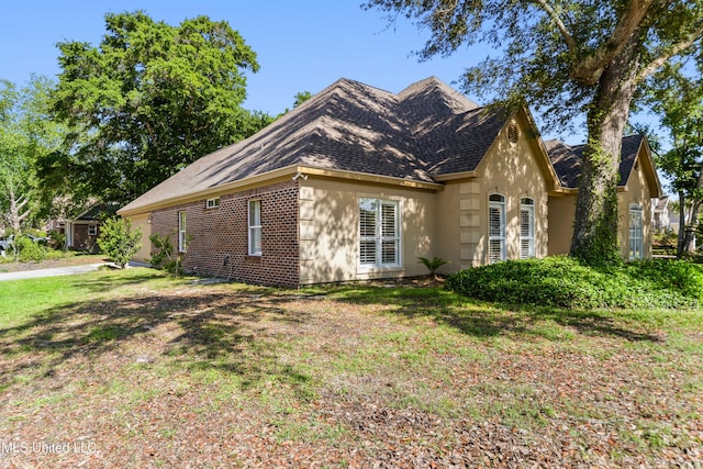 426 Carmargue Ln, Biloxi, MS 39531 - view of home's exterior with roof with shingles, a lawn, and stucco siding