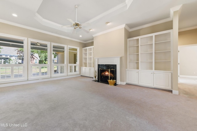 426 Carmargue Ln, Biloxi, MS 39531 - unfurnished living room featuring carpet floors, ceiling fan, a premium fireplace, crown molding, and a tray ceiling